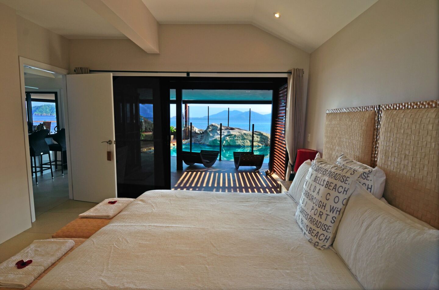Bedroom with a king bed and sliding doors opening onto the deck and sea beyond